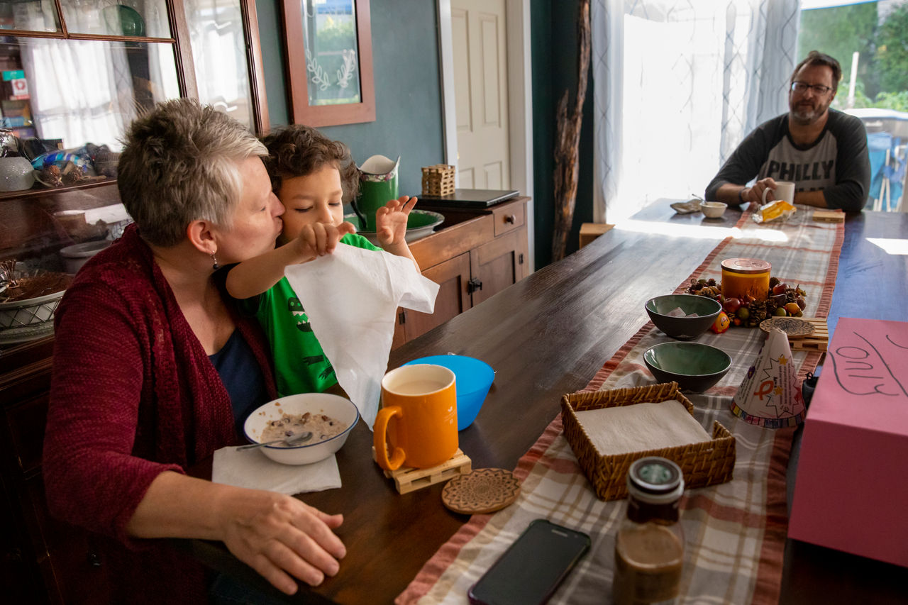 boy and old woman eat breakfast together