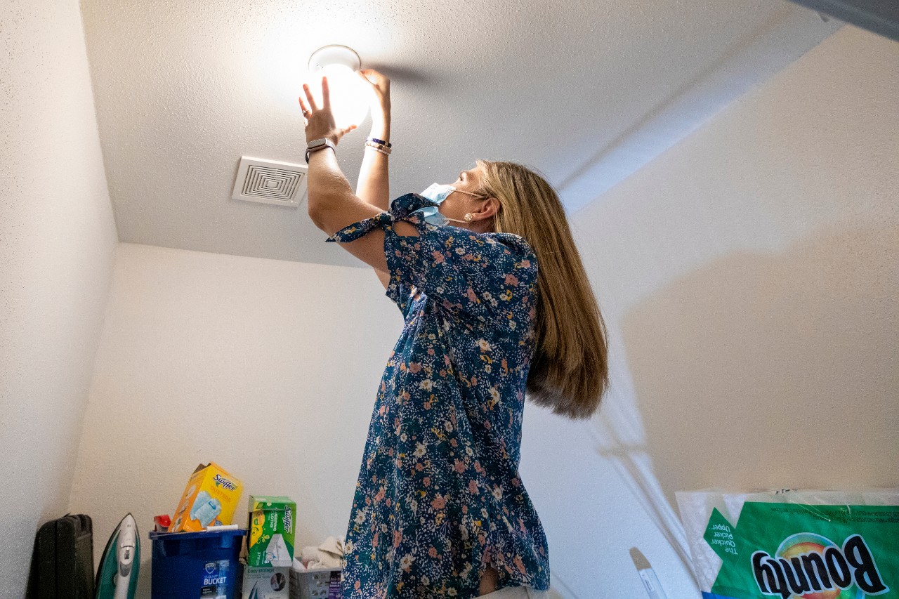 Jane Nodskov (story subject) changes a lightbulb in one of the homes