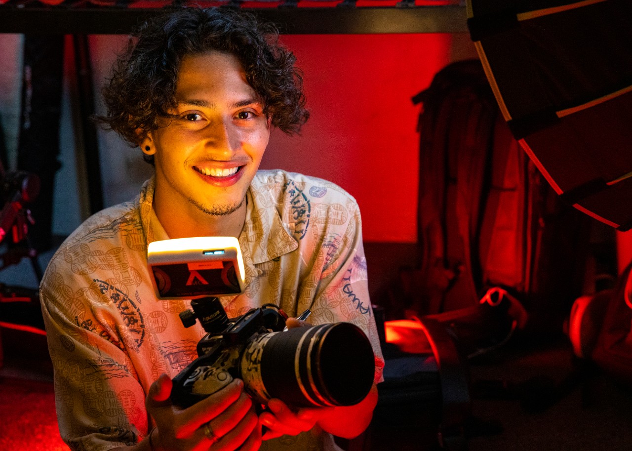 boy smiles as he holds camera