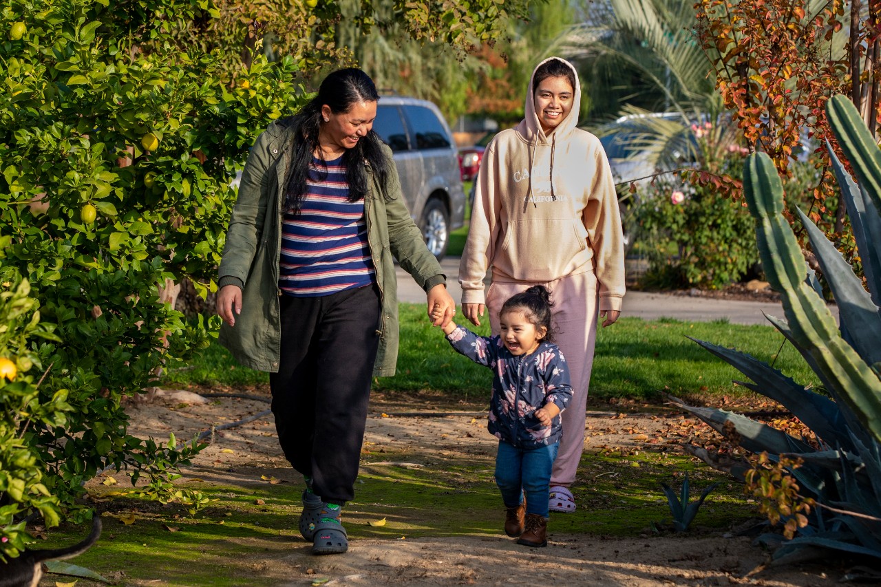 Rossana (left) takes a break from caring for her mother-in-law, Maria, to walk with her daughters Emma (1) and Estefany (18).
