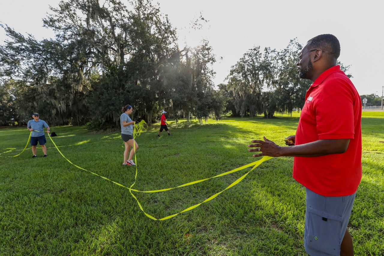 John Oliver, right, director of JAM Camps, helps mark out the volleyball courts with other Cru® staff members at the Winter Haven camp.