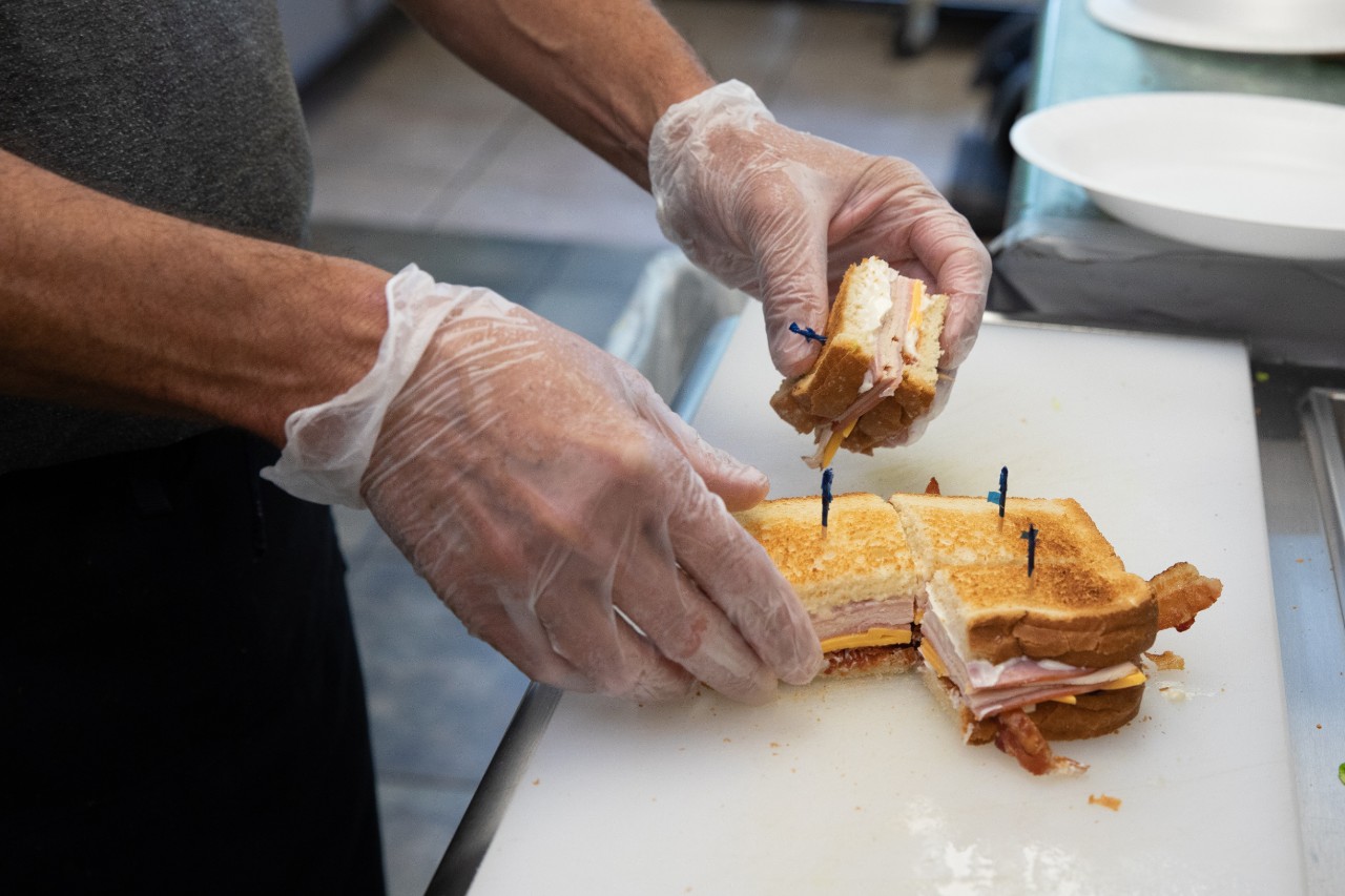 gloved hands make sandwich