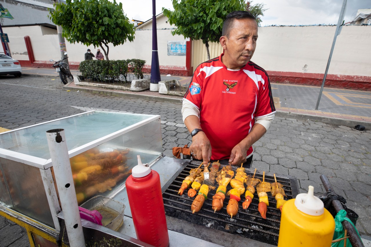 A vendor grills “pinchos,” an Ecuadorian street food.