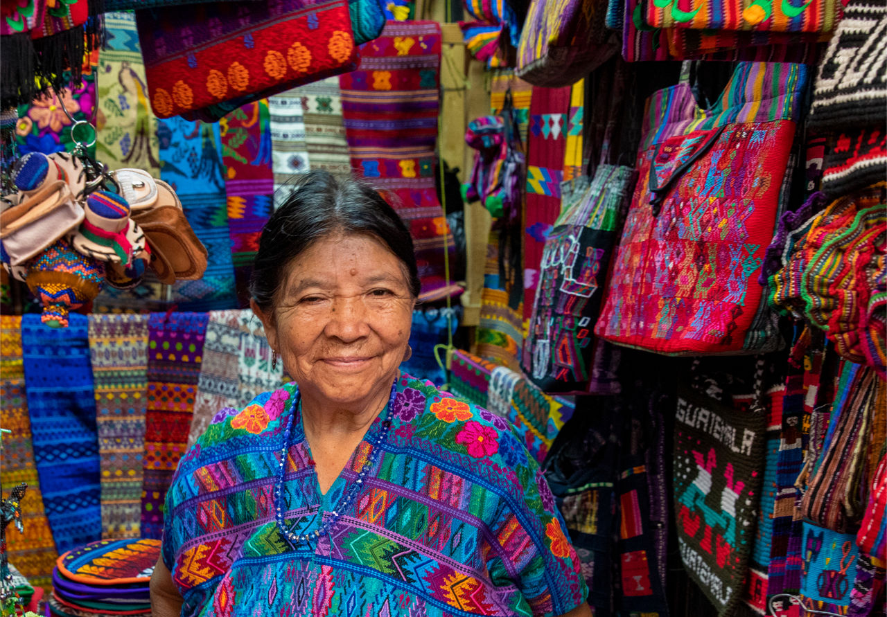 A woman sells woven goods in the historic Spanish colonial city of Antigua, now a popular tourist destination.