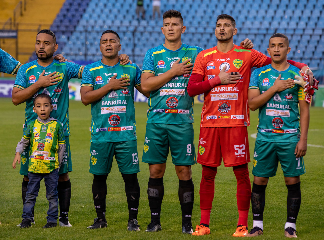 Xinabajul Soccer Club players sing the Guatemalan national anthem before their match against top-ranked Comunicaciones Soccer Club in the national soccer stadium.