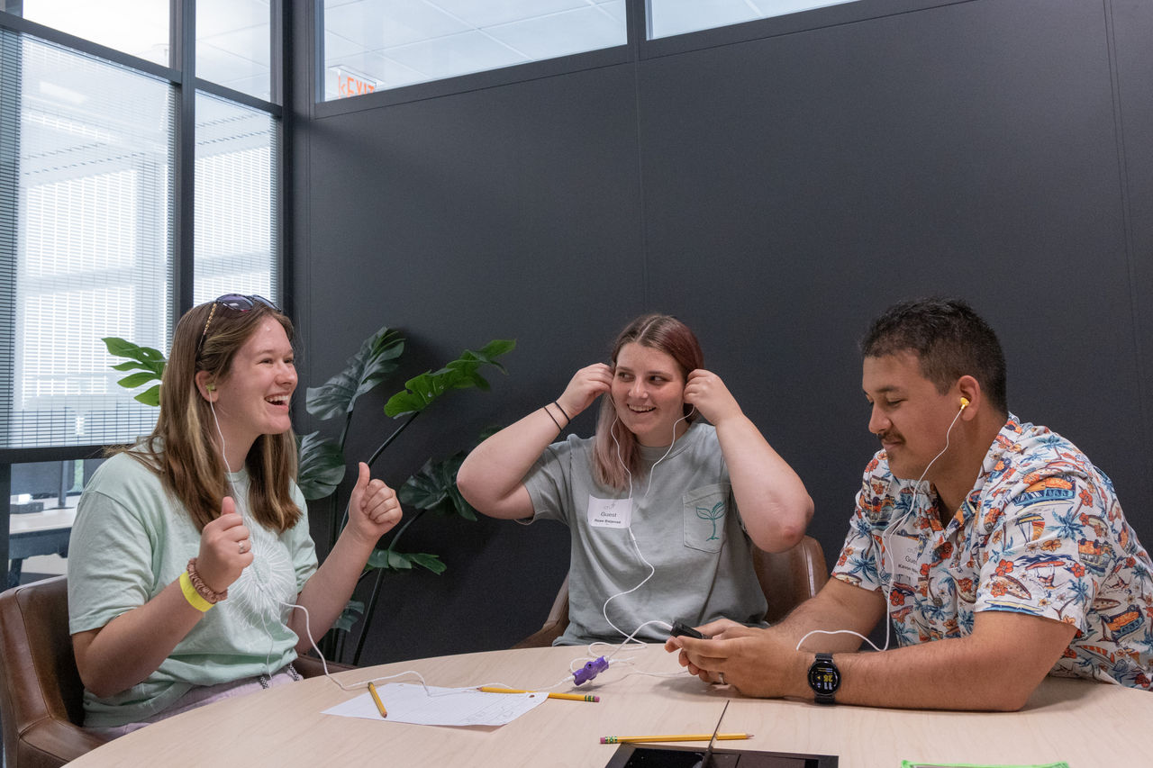 At Cru’s headquarters, Carrisa celebrates getting the story details right with Rose (center) and Kavon.