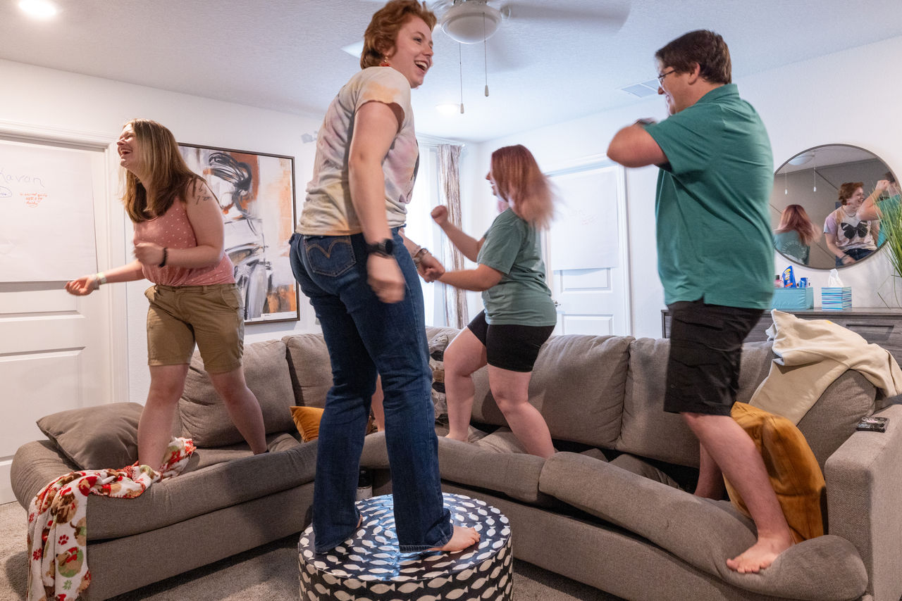 students stand on couch and ottoman