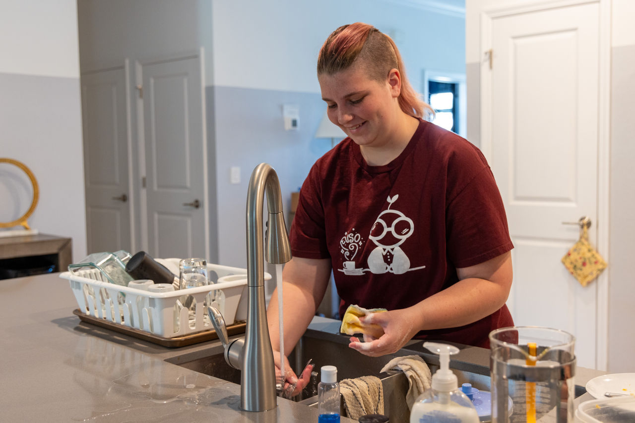 Rose cleans up after dinner at the house, where all the students take turns doing chores.