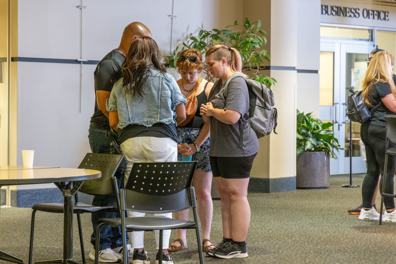  In UCF’s student union, Lillian (with sunglasses) and Rose pray with an alumni couple bringing their daughter to student orientation.
