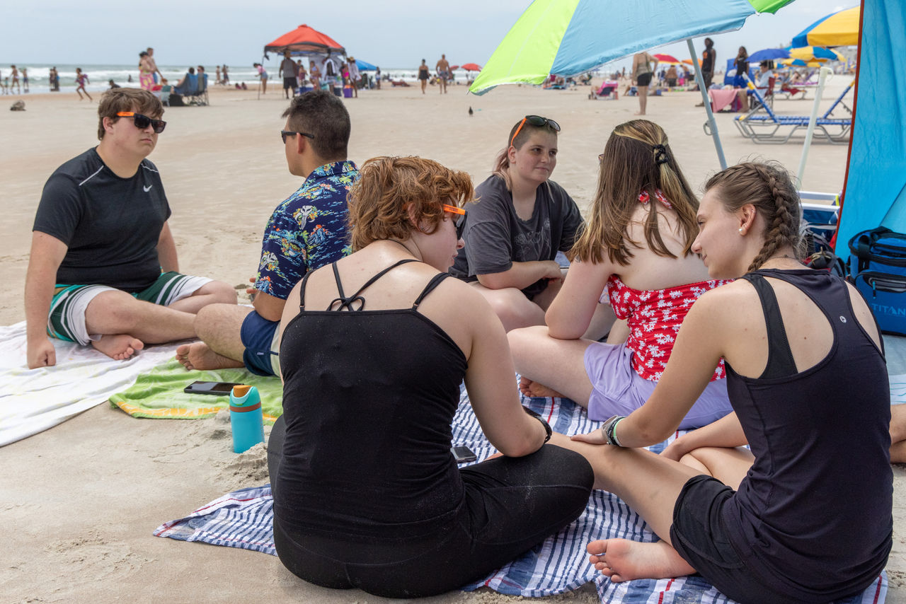 Students pair up to pray together before venturing out to tell Bible stories at the beach.