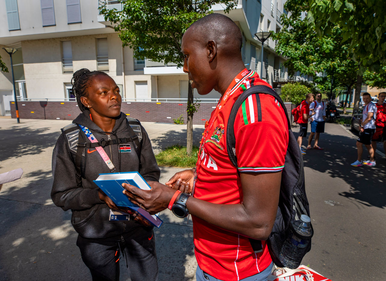 David Cheromei gives a bible to a Kenyan Olympian