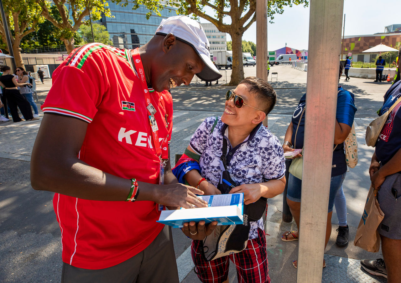 David Cheromei gives a bible to a fan