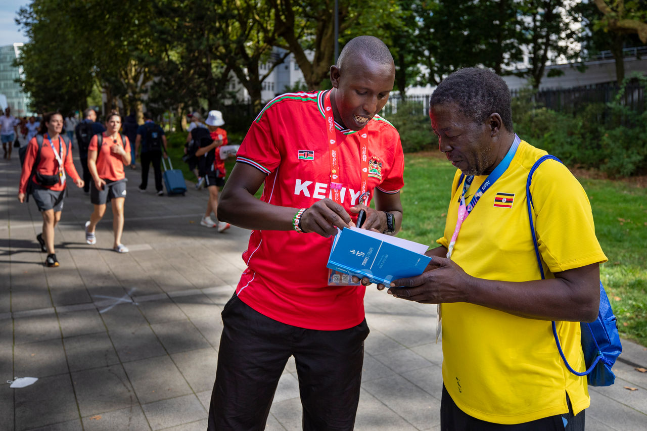 David Cheromei shares an AIA bible with Ugandan Olympic leader