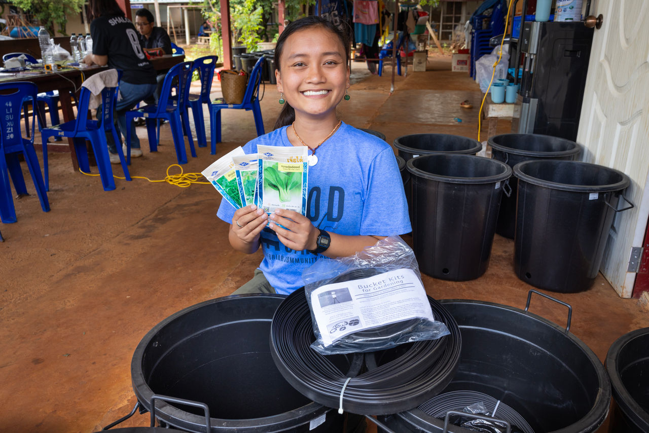 woman volunteer smiling while holding donated items