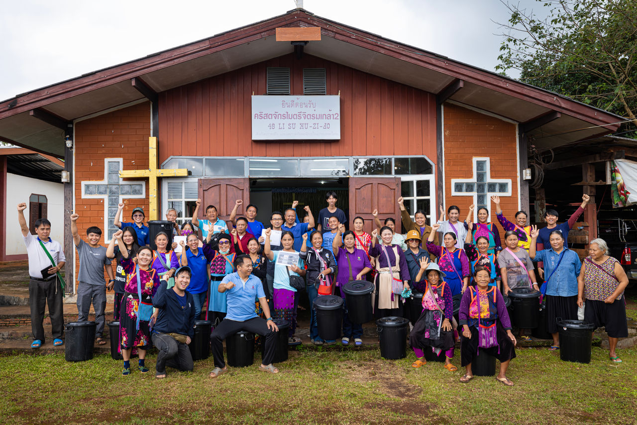 people posing for picture in front of building