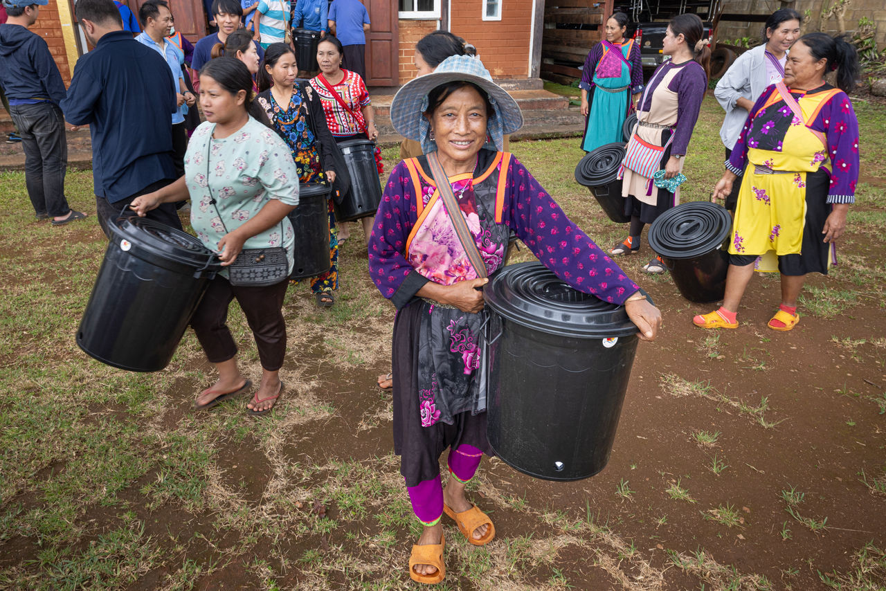 people holding donated items bin smiling